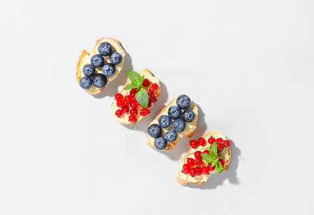 Delicious bruschettas with berries on white background