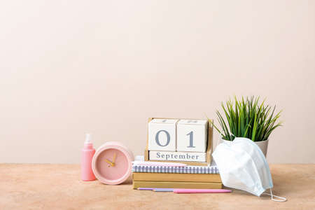 Set of stationery and medical mask on color background