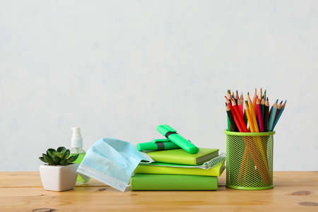 Set of stationery and medical mask on light backgroundの写真素材