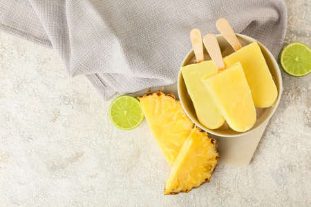 Bowl with tasty pineapple ice creams on light background