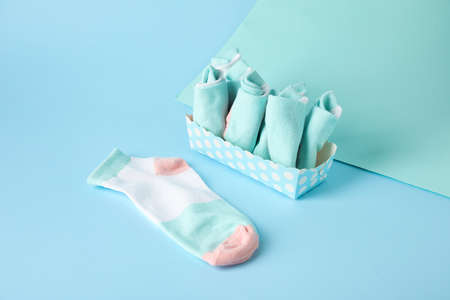 Box with socks on color background