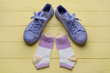 Stylish shoes and socks on wooden yellow background