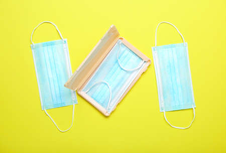 Medical masks with case on yellow background
