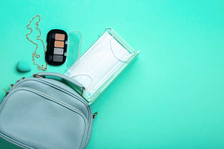 Bag with medical mask, case and cosmetic products on color backgroundの写真素材