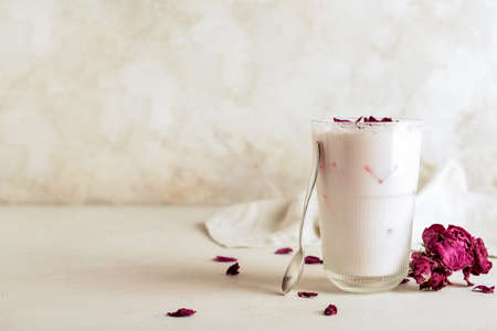 Glass of tasty rose latte on light backgroundの写真素材