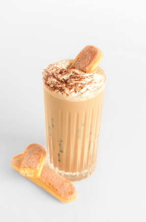 Glass of tasty Tiramisu Latte on light background