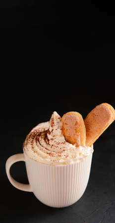 Cup of tasty Tiramisu Latte on black backgroundの写真素材
