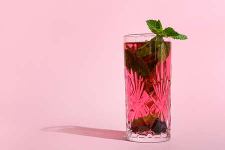 Glass of delicious cocktail on pink backgroundの写真素材