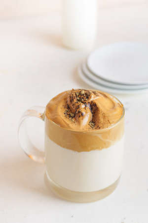 Glass cup of tasty dalgona hojicha latte on light backgroundの写真素材