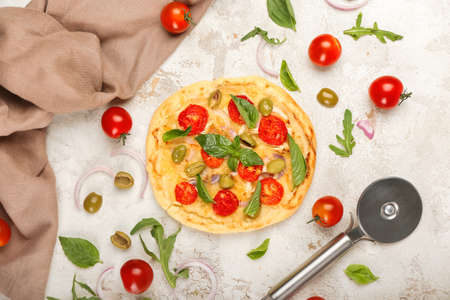 Composition with delicious mini pizza and cutter on light backgroundの写真素材