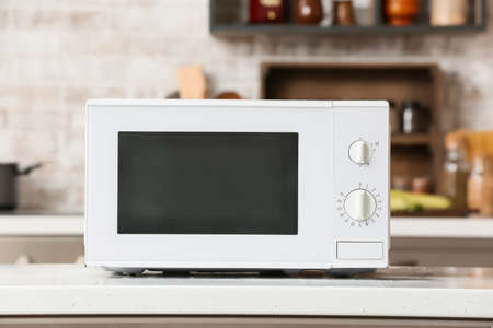 Modern microwave oven on counter in kitchenの写真素材