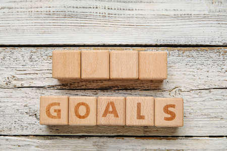 Cubes with word GOALS on light wooden background