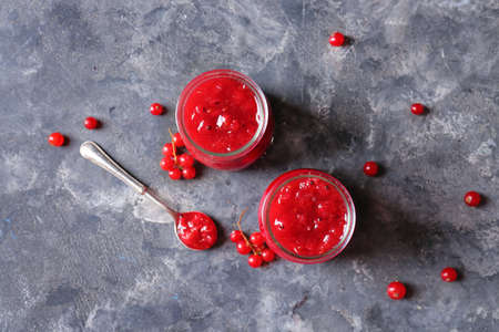 Jars of red currant jam on dark background