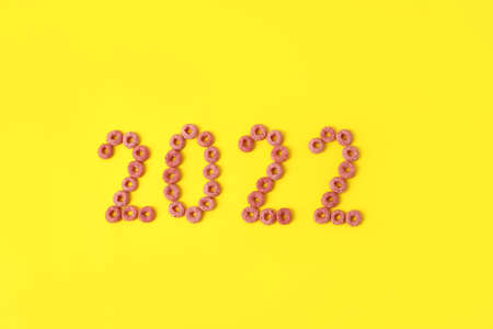 Figure 2022 made of cereal rings on yellow background