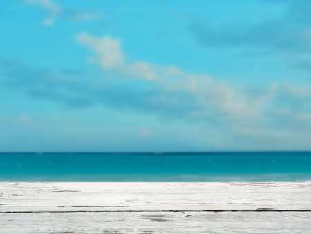Empty wooden surface against blue sea and sky with clouds