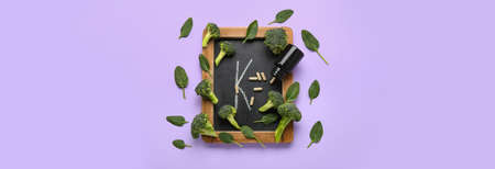 Chalkboard with letter K, bottle of pills, broccoli and spinach leaves on lilac background with...