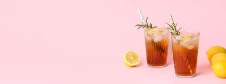 Glasses of tasty iced black tea with lemon on pink background with space for textの写真素材
