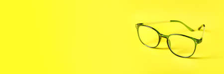 Eyeglasses on yellow background with space for text