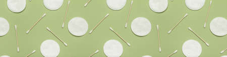 Cotton pads and swabs on green background. pattern for design