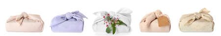 Set of gifts wrapped in fabric on white background