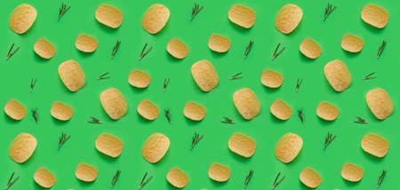 Tasty potato chips and herbs on green background. texture for designの写真素材