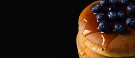 Tasty pancakes with honey and berries on dark background, closeupの写真素材