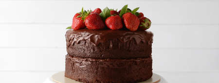 Tasty chocolate cake with fresh strawberries on white wooden backgroundの写真素材