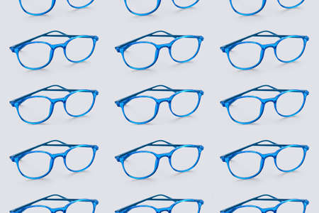 Stylish eyeglasses on light blue background. pattern for designの写真素材