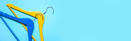 Clothes hangers on light blue background with space for text, top viewの写真素材