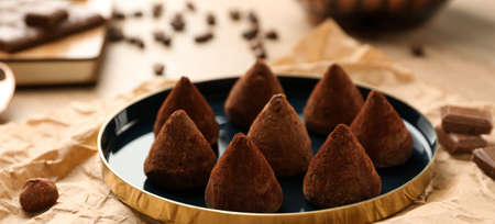 Plate with tasty chocolate truffles on table