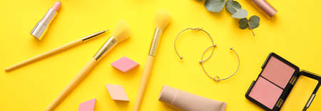 Different makeup products and accessories on yellow background. Banner designの写真素材
