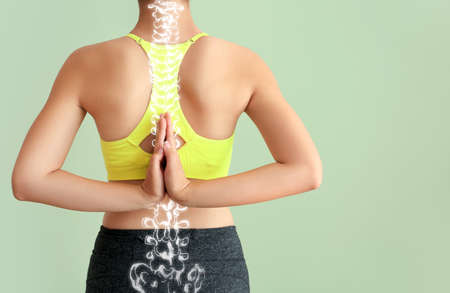 Sporty young woman with healthy spine on color background