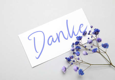 Card with word DANKE (German for Thanks) and flowers on light backgroundの写真素材