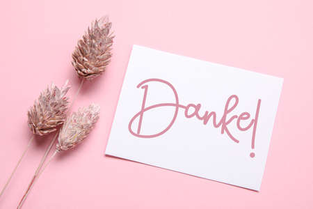 Card with word DANKE (German for Thanks) and floral decor on pink background