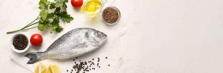 Raw dorado fish with spices, oil and herbs on light background with space for text
