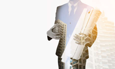 Double exposure of architect with drawings and buildings on white backgroundの写真素材