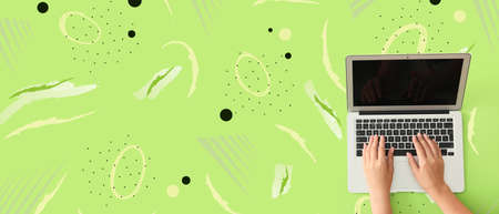 Hands using modern laptop on green background with space for text