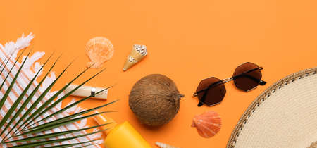 Set of beach accessories, tropical palm leaf and coconut on orange background