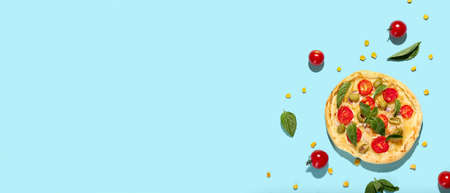 Composition with delicious mini pizza and ingredients on light blue background with space for textの写真素材