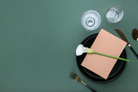 Beautiful table setting with blank card and white calla lily on color backgroundの写真素材