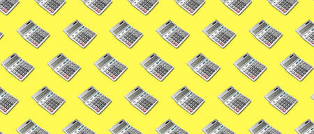 Many calculators on yellow background. pattern for designの写真素材
