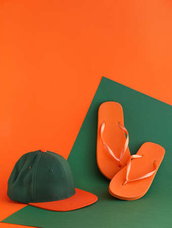 Cap and flip flops on color backgroundの写真素材
