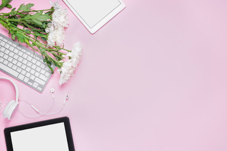 Modern gadgets with flowers on pink backgroundの写真素材