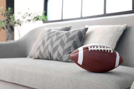 Rugby ball on comfortable sofa in living room, closeupの写真素材