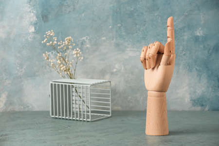 Wooden hand with raised index finger on blue backgroundの写真素材