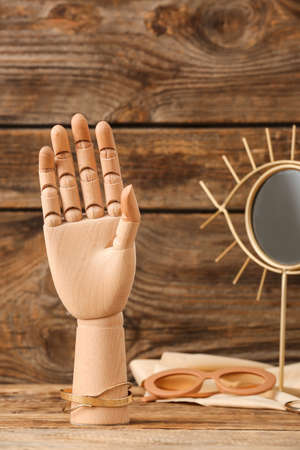 Decorative hand with jewelry and mirror on wooden backgroundの写真素材
