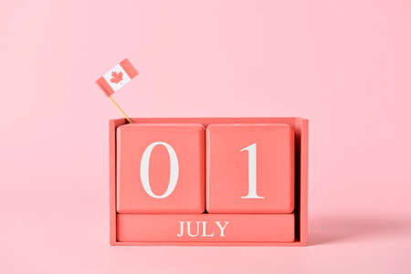 Cube calendar with date July 1 and small Canadian flag on color background. Happy Canada Day