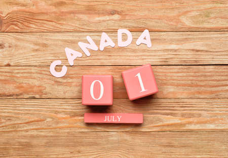 Cube calendar with date JULY 1 and word CANADA on wooden background. Happy Canada Dayの写真素材