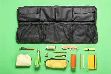 Composition with travel organizer and different things on green background