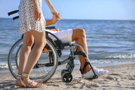 Young woman and her boyfriend with physical disability at sea resort